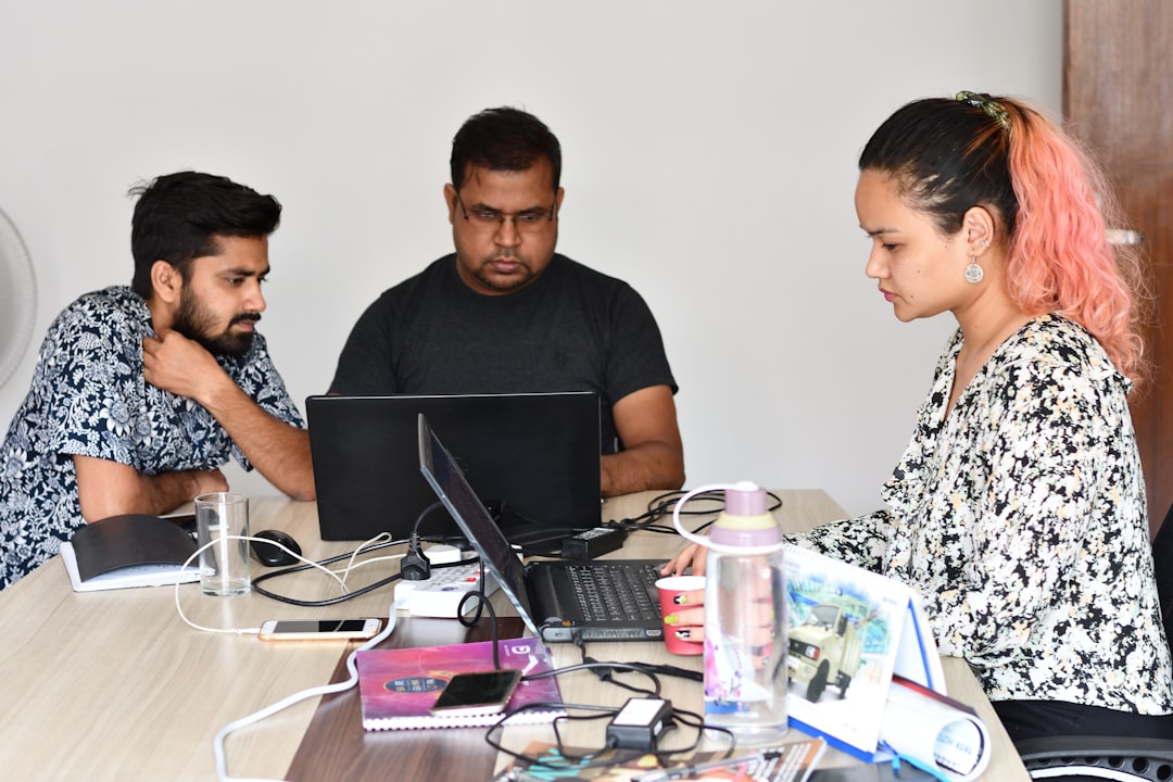 man in black crew neck t shirt sitting beside woman in black and white floral dress customer support problem solving professional team