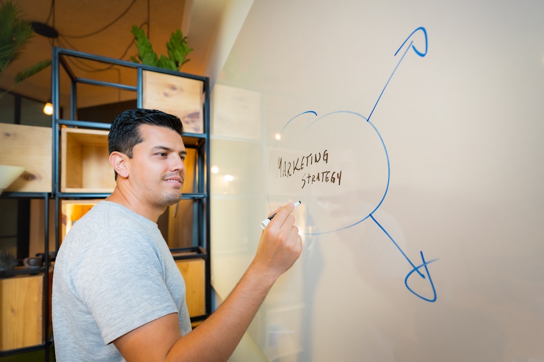 man in gray crew neck t shirt standing near white wall marketing team planning session strategy board
