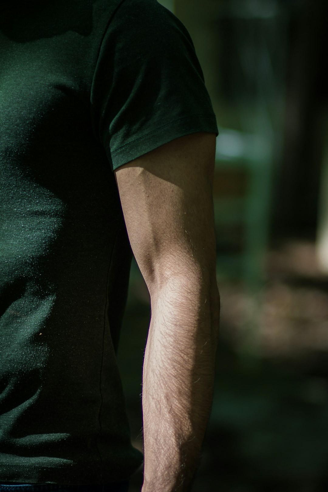 man in green t shirt arm flexion biceps muscle elbow joint