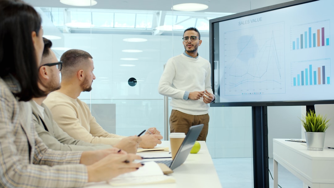 man presenting charts to colleagues in a meeting marketing team performance report video advertising