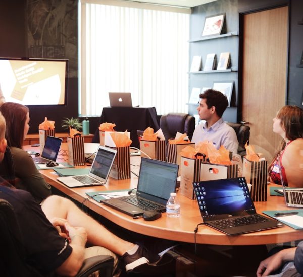 Best 6 Business Apps for Small Teams and Growing Companies in 2026 10 man standing in front of people sitting beside table with laptop computers leadership discussion planning session progress charts collaboration 1