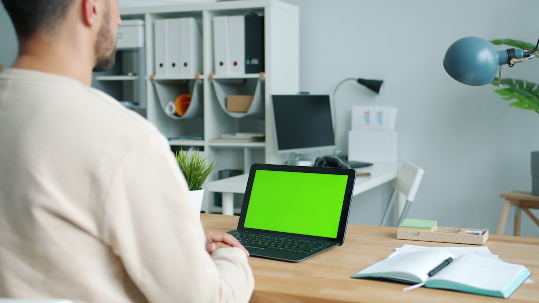 man working on laptop with green screen shared folders remote workers digital documents