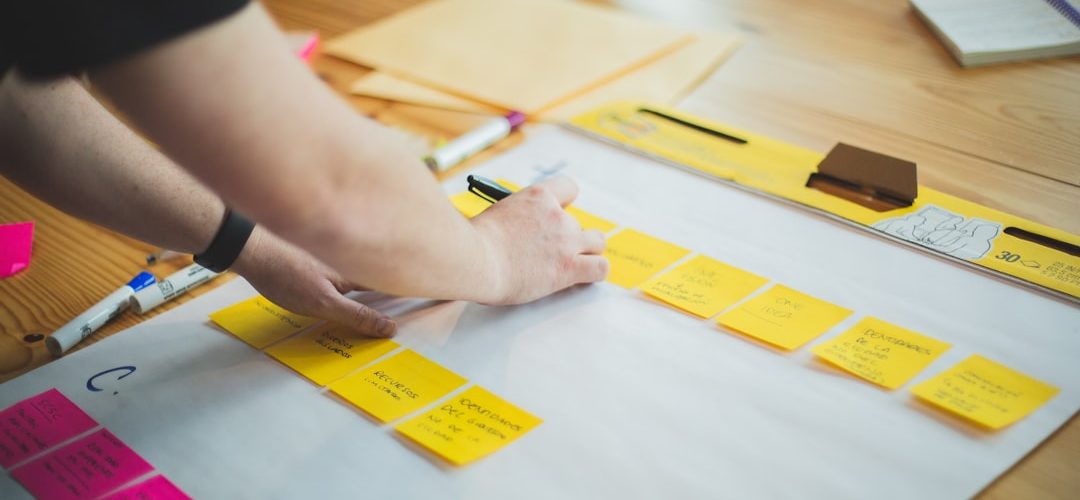 person writing on white paper marketing team planning session strategy board