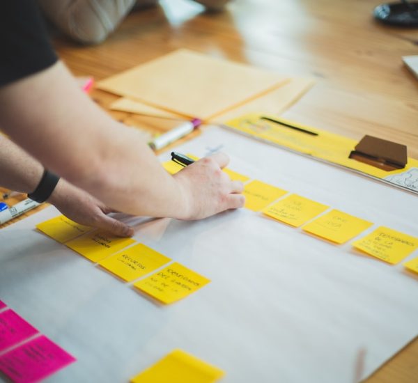 person writing on white paper marketing team planning session strategy board