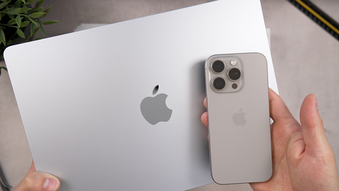 silver apple laptop and iphone held by hands macbook iphone ipad productivity app apple ecosystem