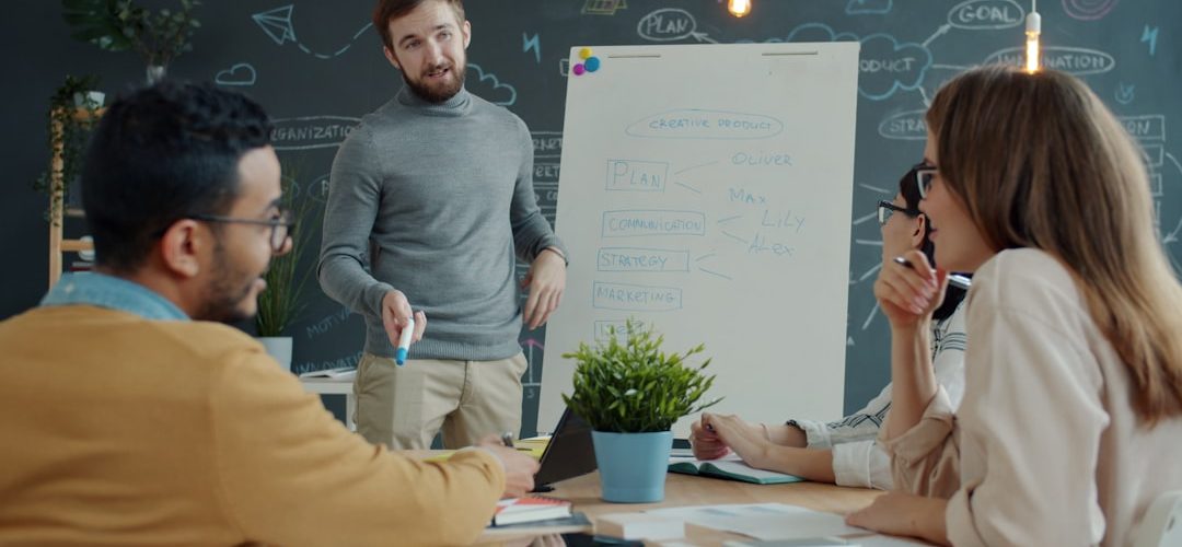team collaborating around a whiteboard during a meeting company meeting team presentation office audience