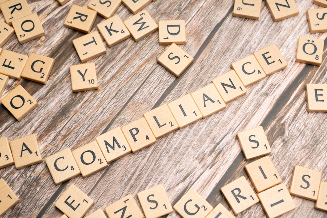the word compliance spelled out with wooden letter tiles on a rustic table legal compliance privacy rules responsible data