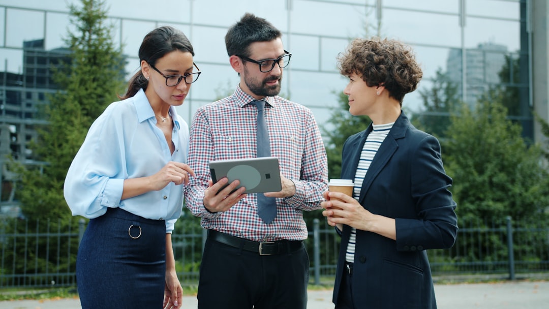 three colleagues discussing a tablet outside an outdoor setting business communication teamwork secure chat