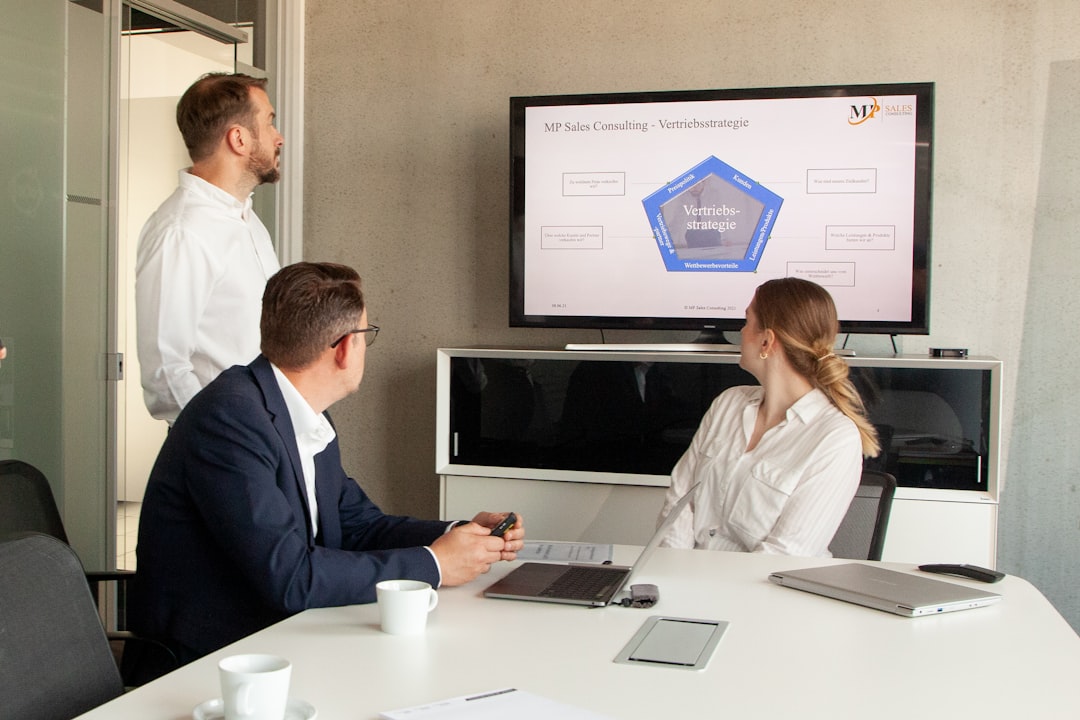 three people in a meeting room looking at a presentation logistics team crm dashboard freight sales