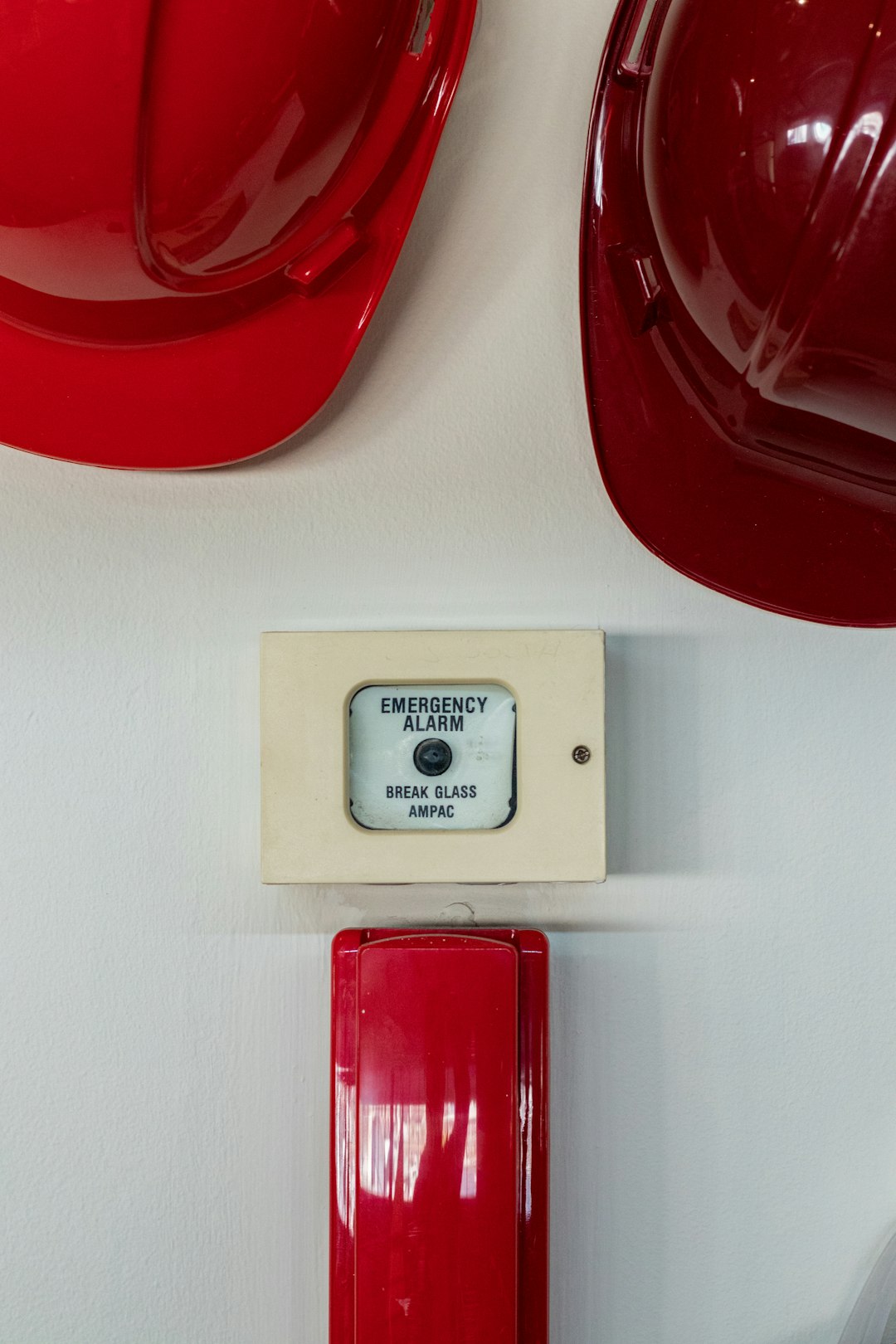 two red hard hats near emergency alarm button technician installation wall mounted intercom safety equipment 1