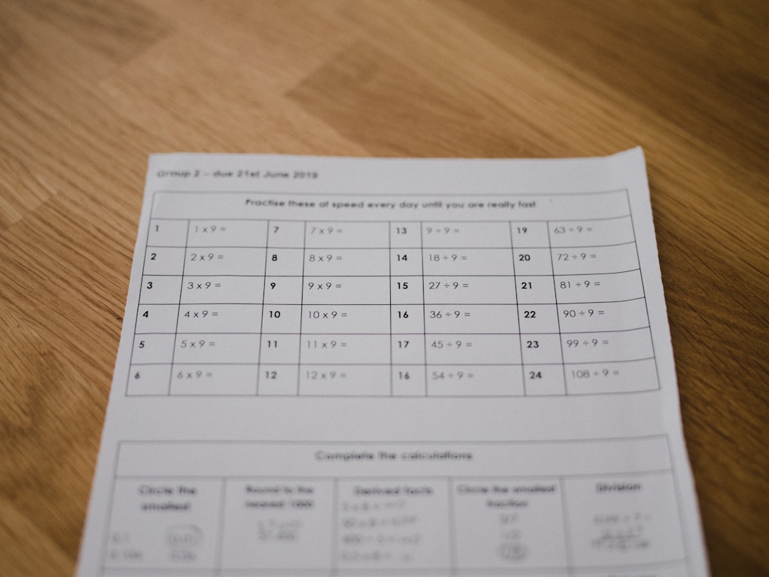 white printer paper on brown wooden surface student solving math worksheet answers algebra notebook