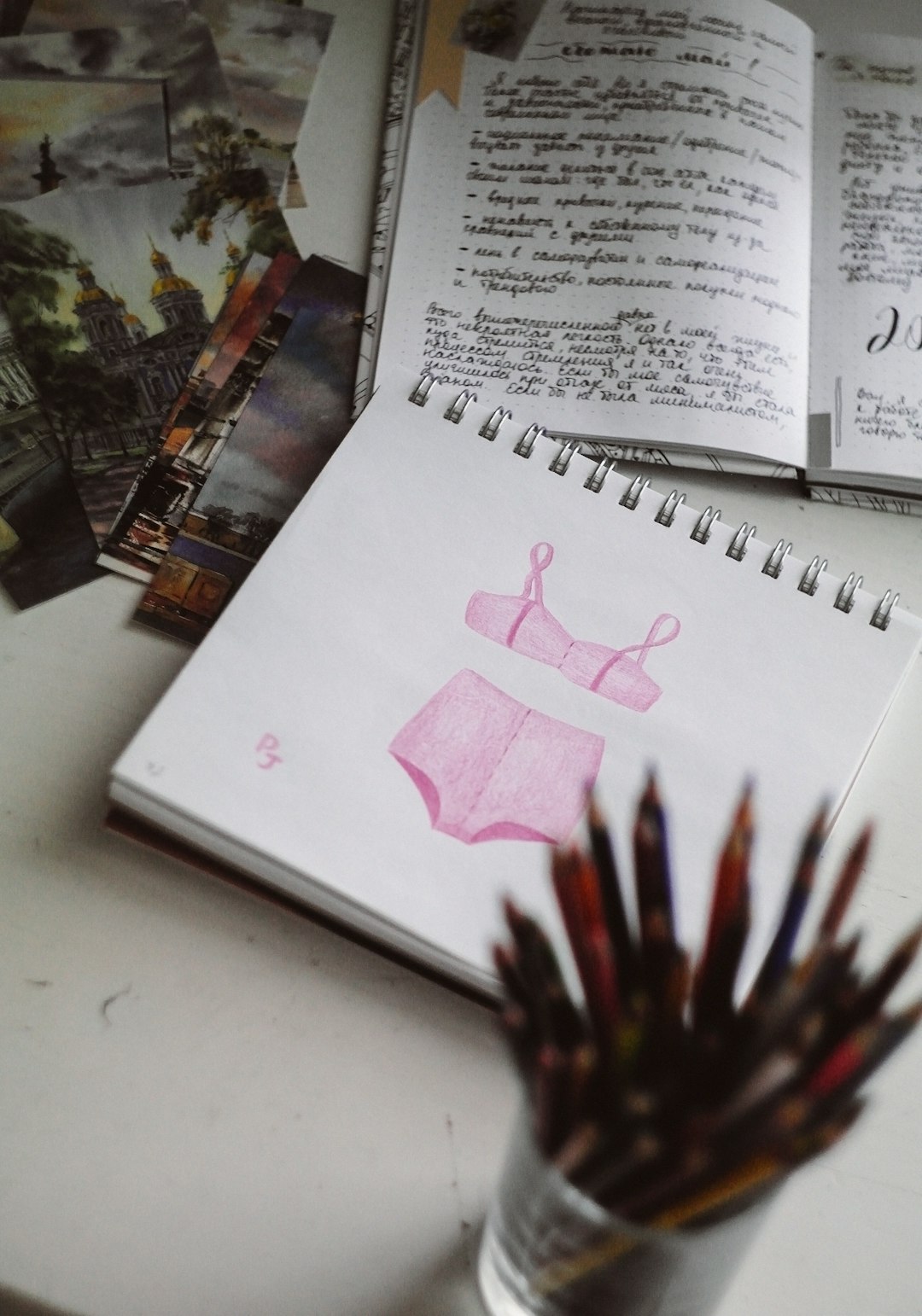 white printer paper on white table fashion portfolio mood board styled outfits creative desk