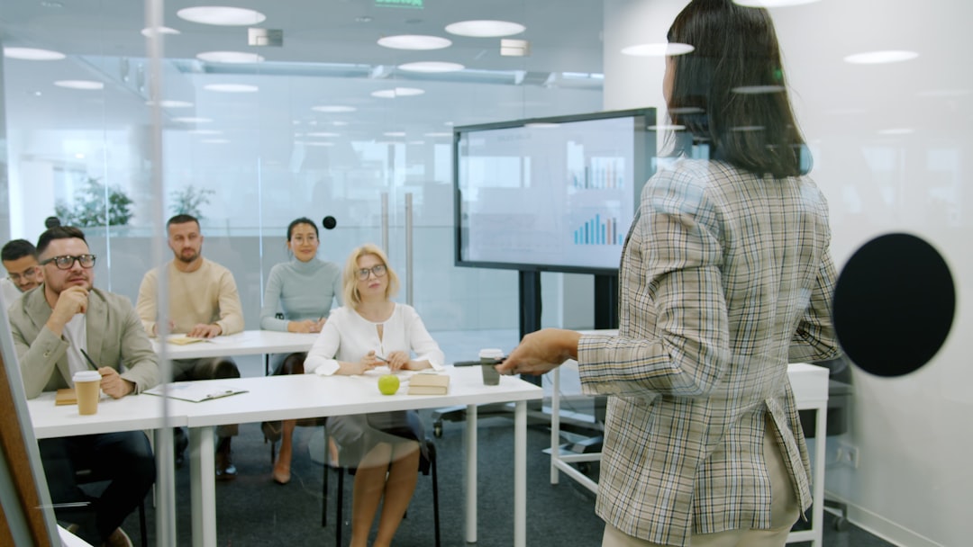 woman presenting to an attentive audience in a modern office company meeting team presentation office audience