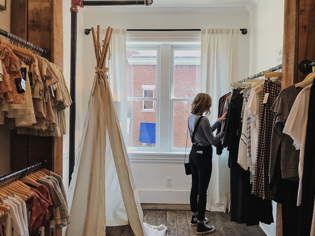 woman standing selecting clothes personal shopper wardrobe consultation client fitting boutique