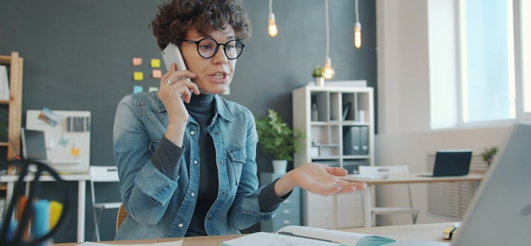 woman talking on phone at desk with laptop support agent headset customer conversation service desk
