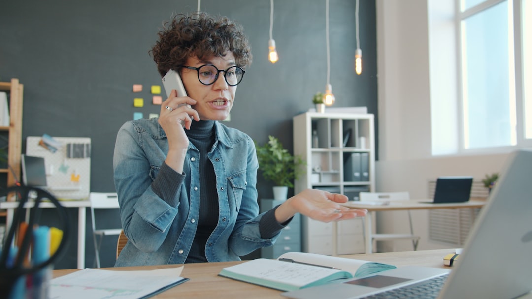 woman talking on phone at desk with laptop support agent headset customer conversation service desk