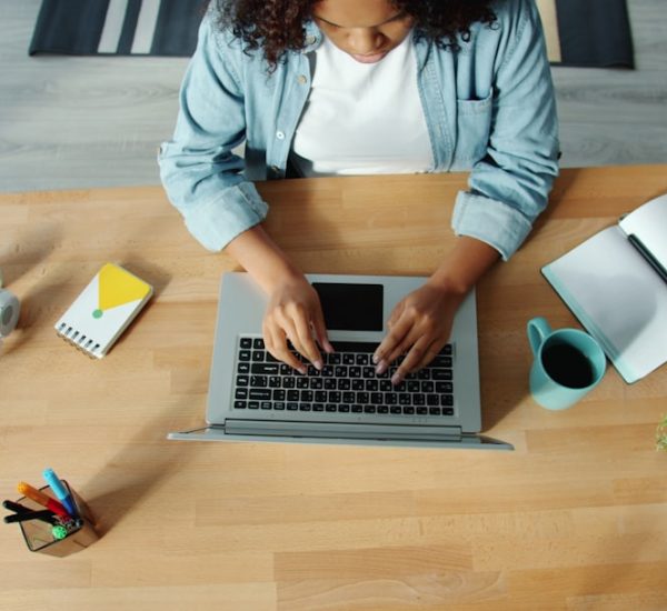 woman typing on laptop at a wooden desk shared folders remote workers digital documents 1