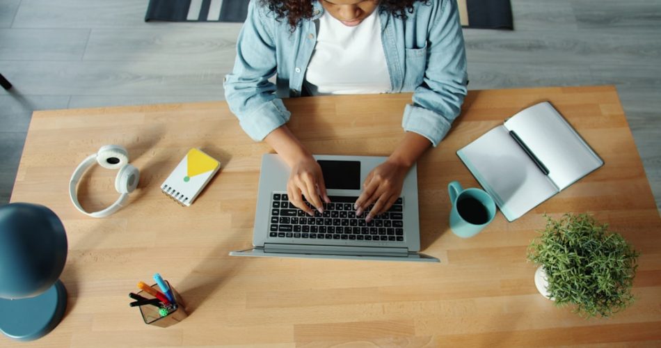 woman typing on laptop at a wooden desk shared folders remote workers digital documents 1