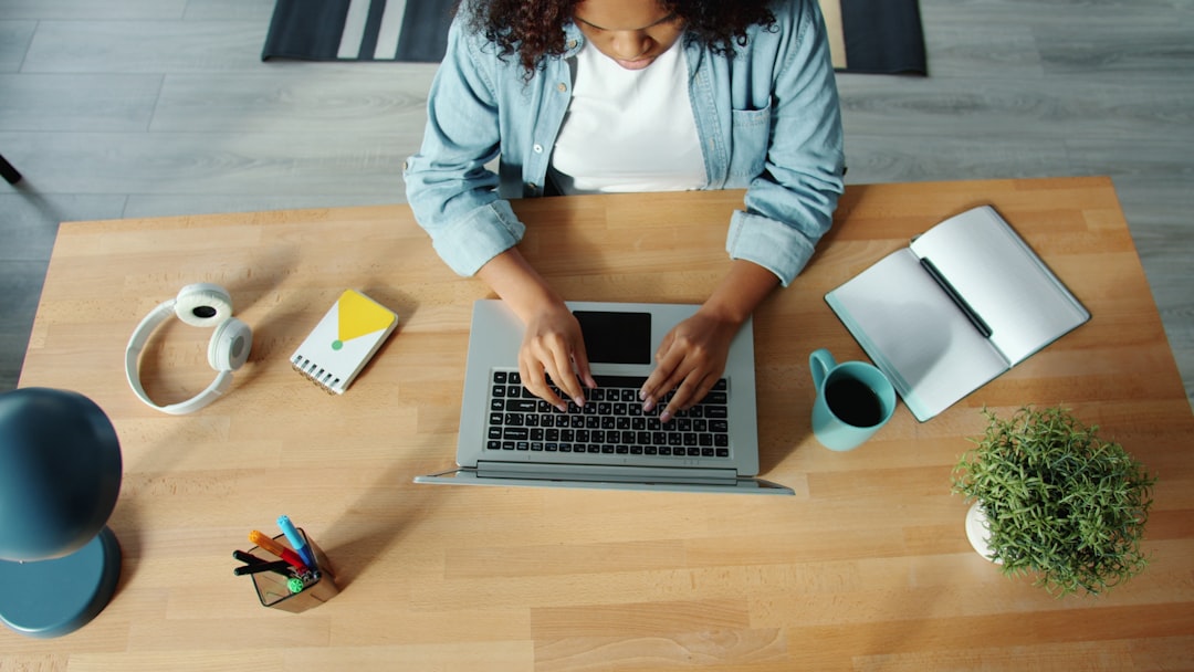 woman typing on laptop at a wooden desk shared folders remote workers digital documents 1