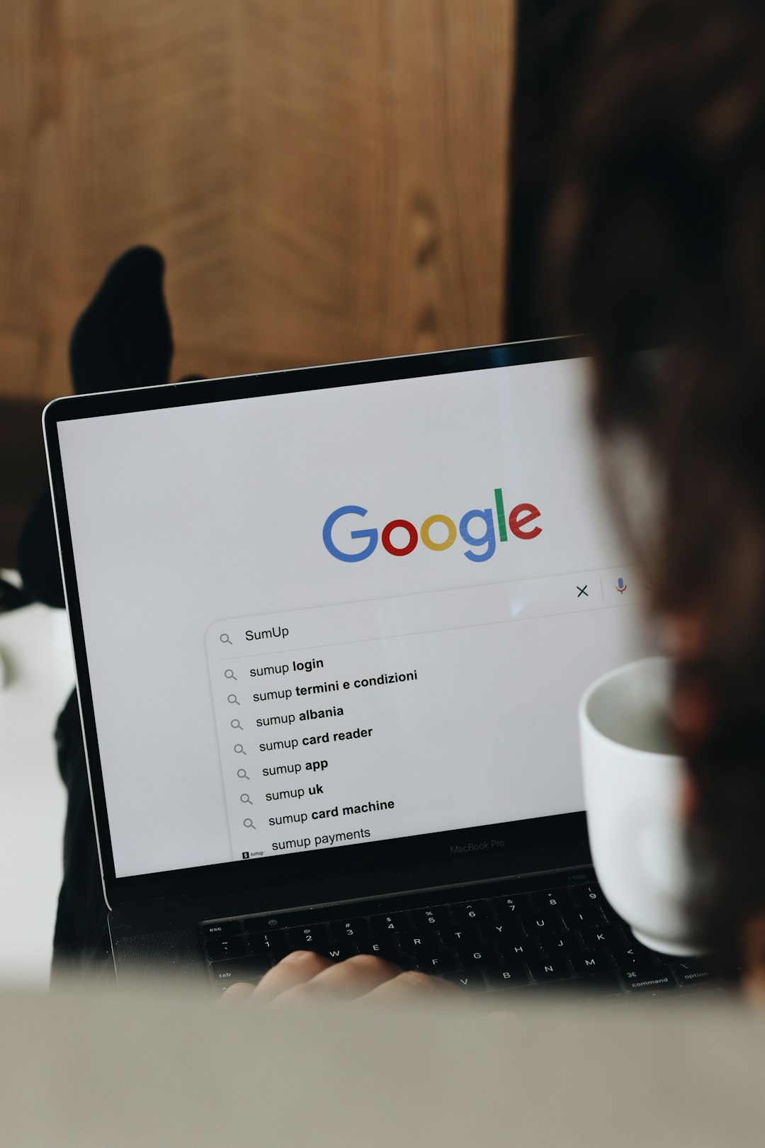 a person sitting in front of a laptop computer google search results related searches keyword research