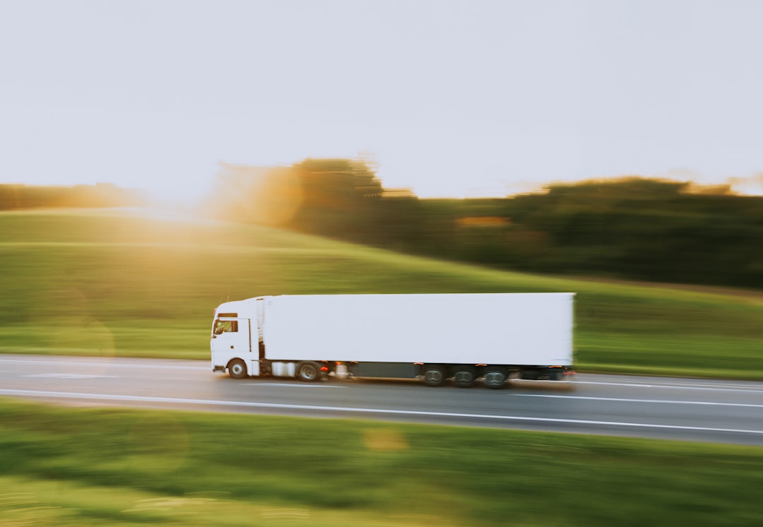 a white semi truck driving down a rural road transportation integrations api connections logistics software