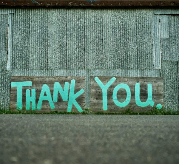 Nonprofit Newsletter: Mailchimp vs beehiiv for Nonprofit Newsletter Campaigns 9 a wooden sign painted with the words thank you against a corrugated metal wall fundraising team donor thank you nonprofit office