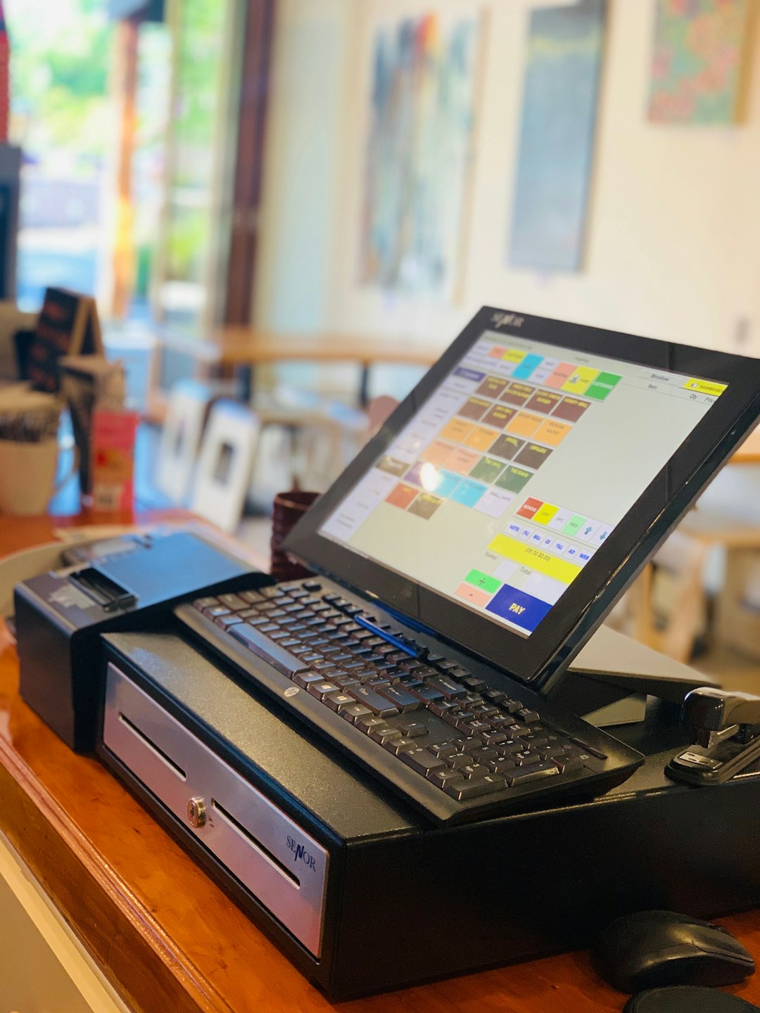 black laptop computer on brown wooden table pos comparison payment terminals small business technology