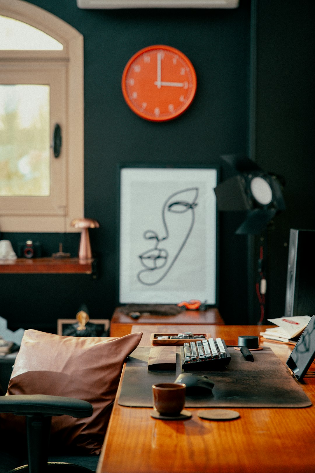 desk with artwork and orange clock freelance designer creative workspace software alternatives