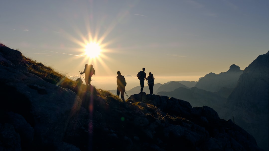 four person on mountain during daytime mountain summit ambitious team future vision
