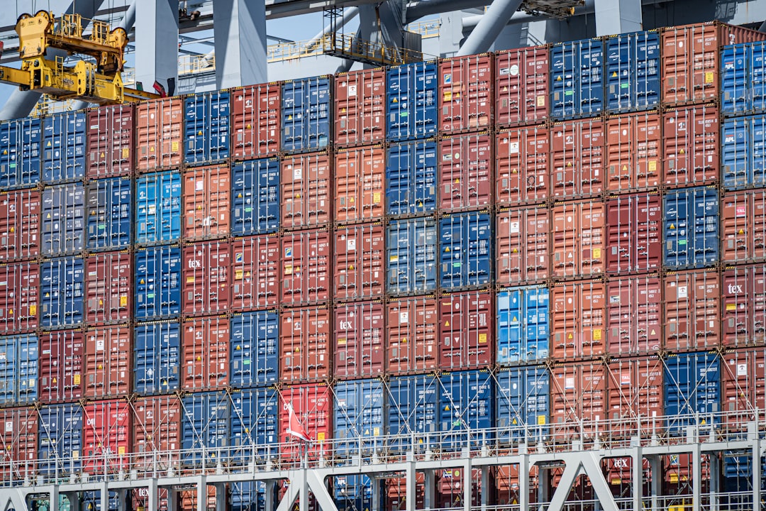 stacked blue and red shipping containers on a cargo ship global freight network cargo routes supply chain map