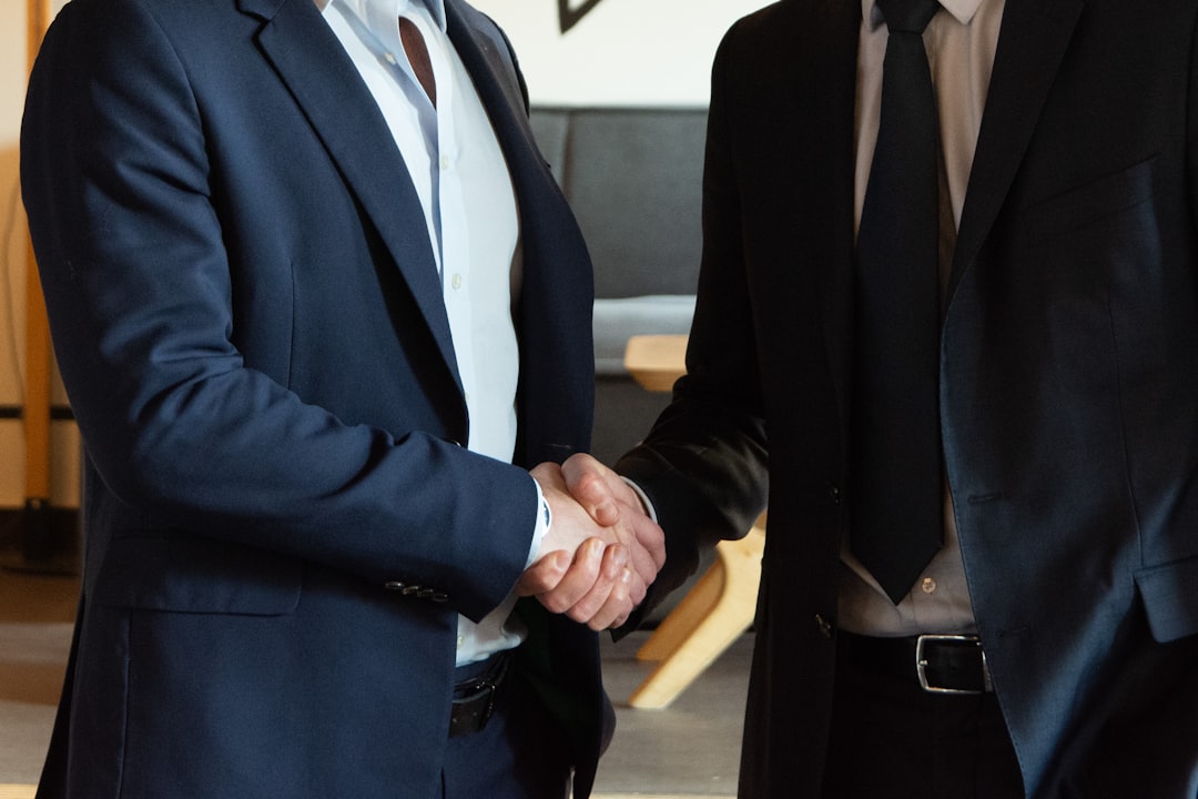 two business partners shaking hands in agreement outside sales client meeting business travel handshake