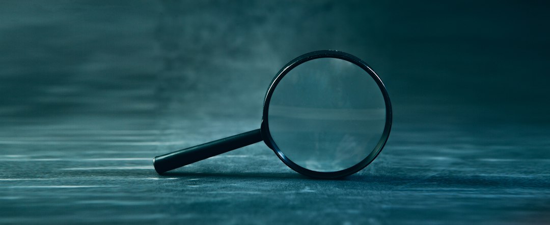 a magnifying glass rests on a textured surface identity check profile cards magnifying glass