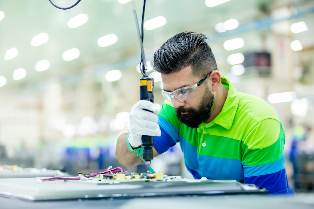 a man in a factory working on a piece of equipment cnc operator safety glasses machine inspection factory floor