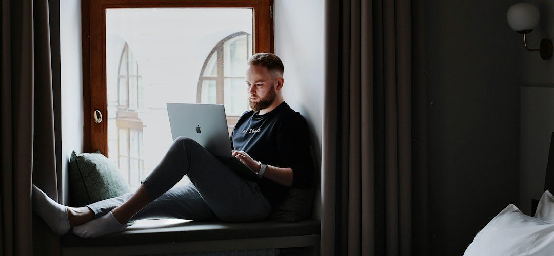 a man sitting on a bed using a laptop computer hotel email dashboard guest segments booking campaign