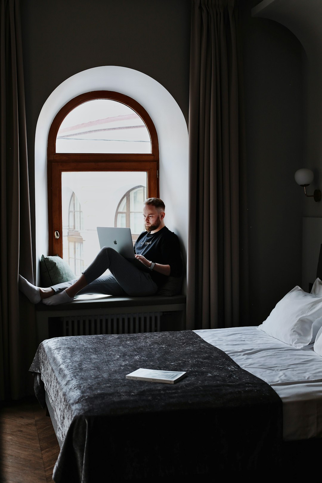 a man sitting on a bed using a laptop computer hotel email dashboard guest segments booking campaign
