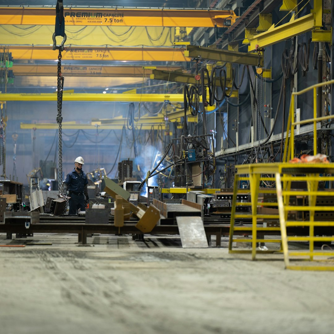 a man standing in front of a machine in a factory cnc machine operator control panel metal shop