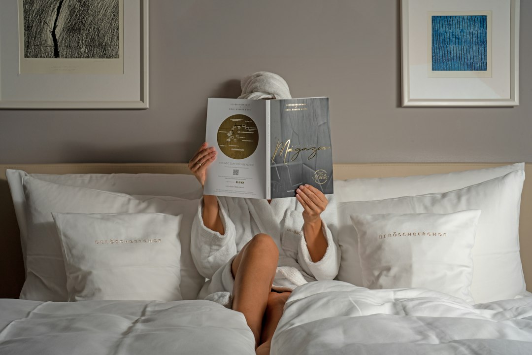 a person reading a book on a bed hotel email dashboard guest segments booking campaign
