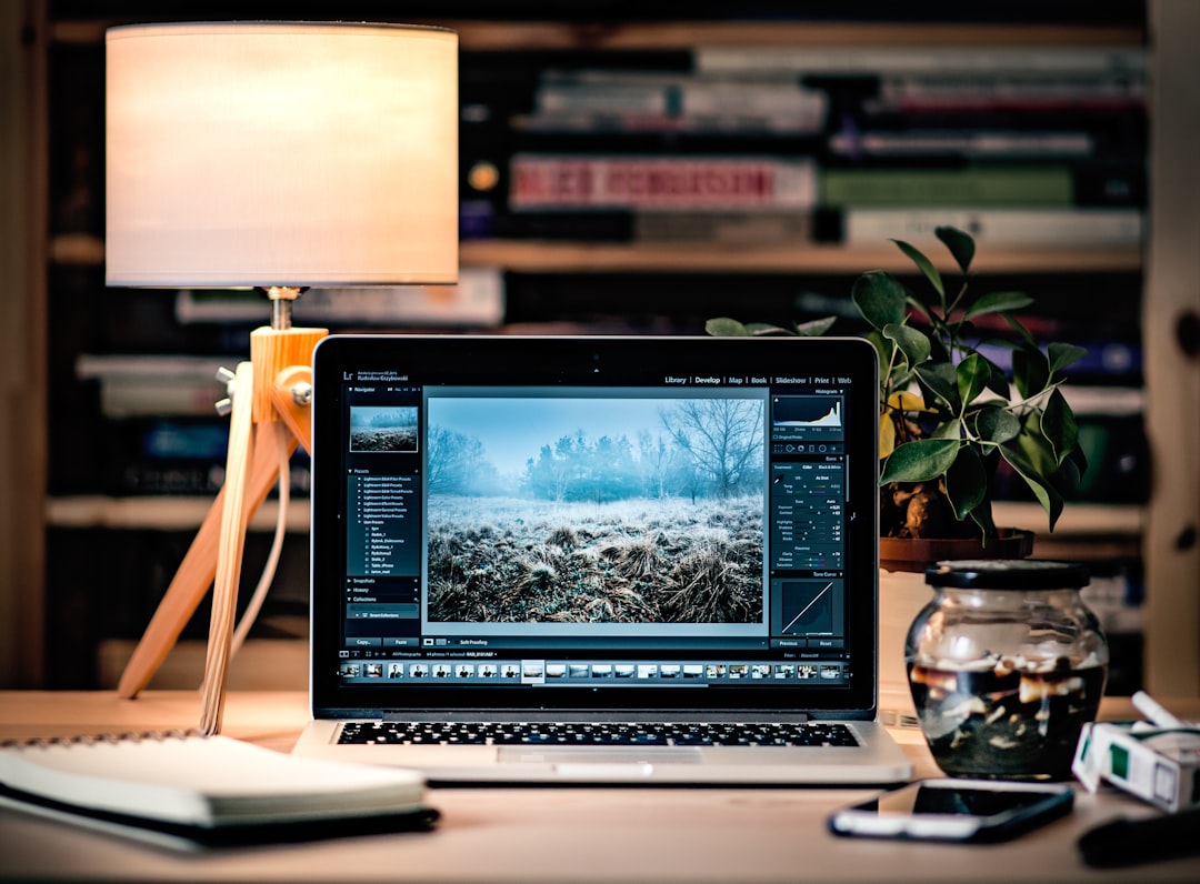 macbook pro on brown wooden table inside room content creator desk laptop editing social video