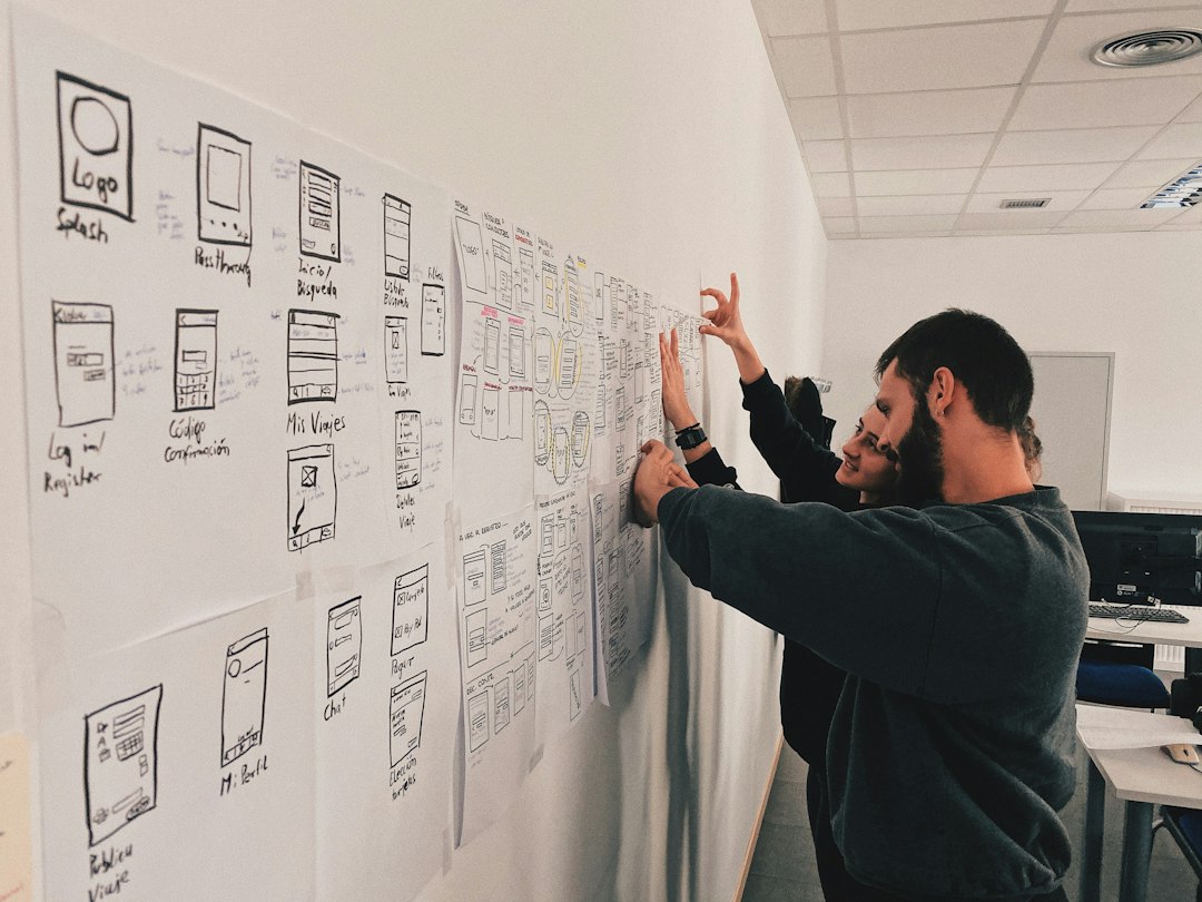 man in gray sweater standing beside wall workflow diagram app concept design presentation