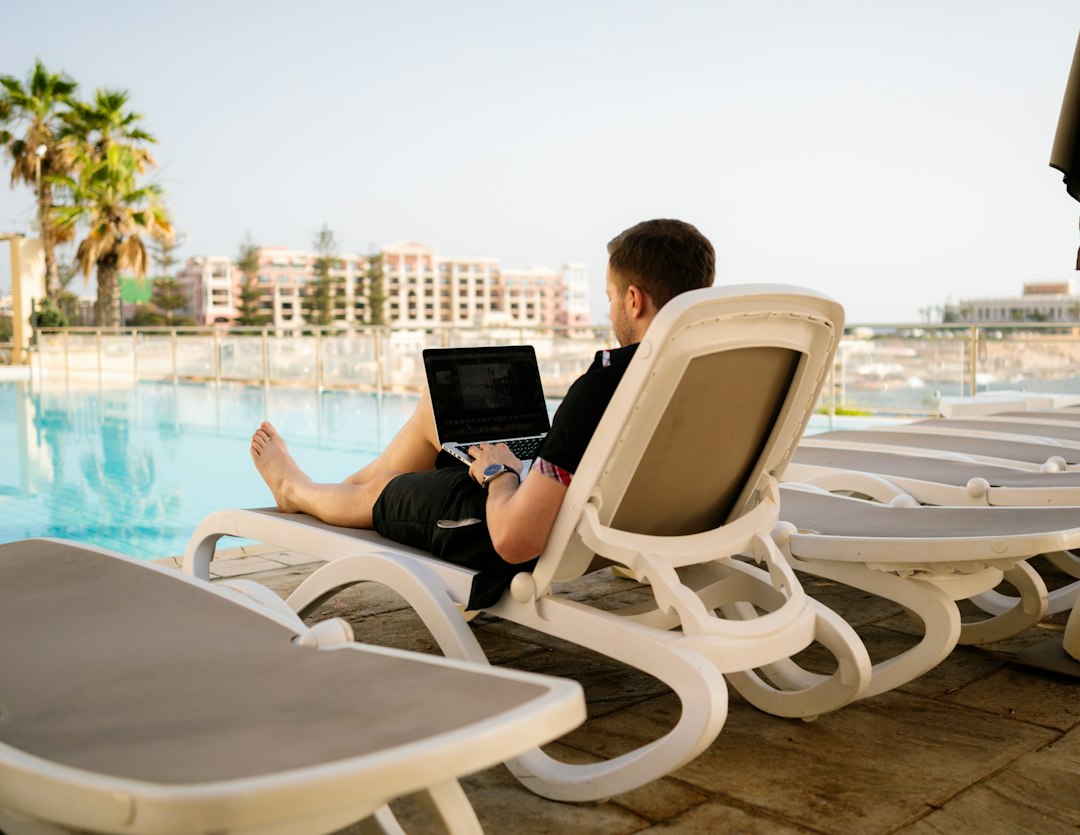 man on sun lounger using laptop resort crm workflow sales pipeline guest follow up