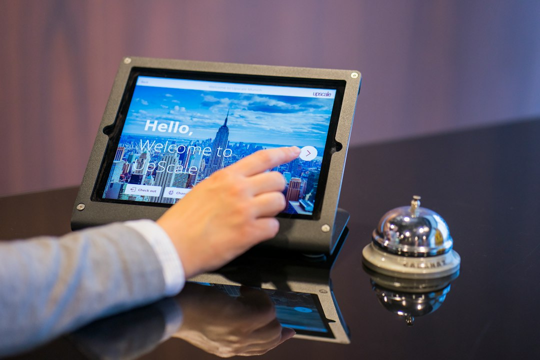 person about to touch black android tablet computer hotel email dashboard guest segments booking campaign