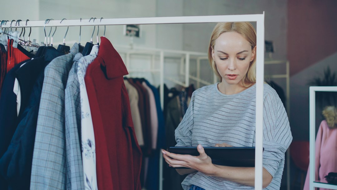 woman reviews garments in clothing store small business owner email template online store