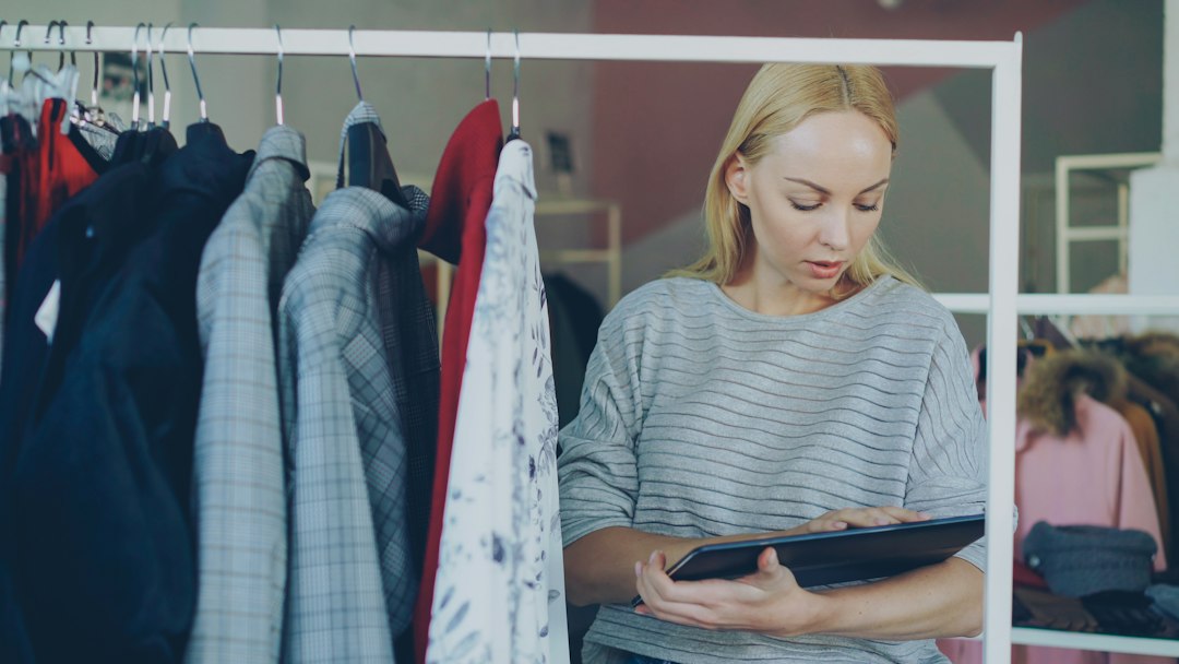 woman reviews inventory in a clothing store small business owner email template online store