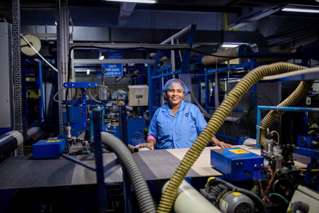 woman works at a factory machine cnc operator safety glasses machine inspection factory floor