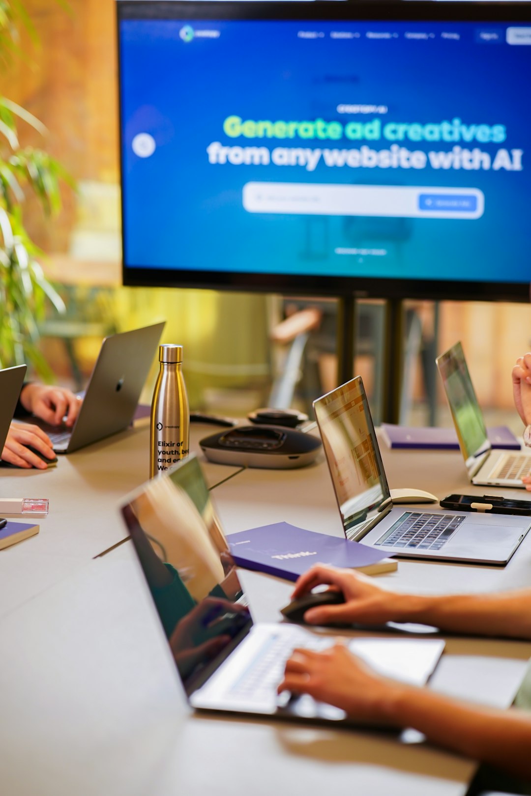 a group of people sitting around a table with laptops public relations team media database campaign planning