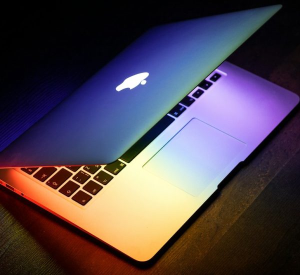 What Is Scareware? How It Compares With Ransomware, Spyware, and Other Malware Threats 6 a macbook lit up in rainbow colors on a wooden surface laptop screen patches colored blocks display defect