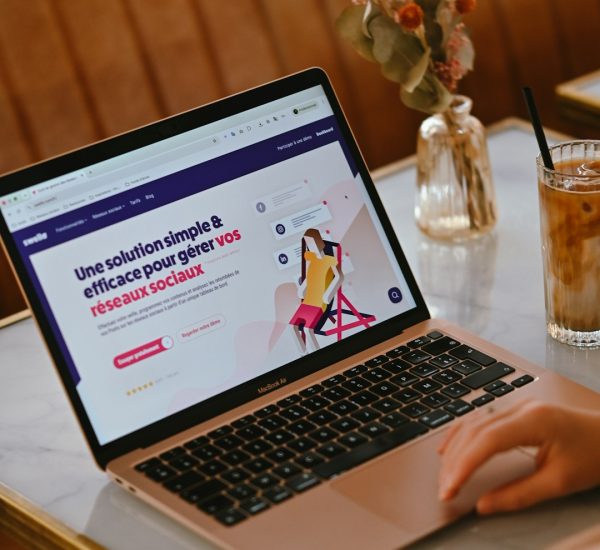 a person using a laptop on a marble table with iced coffee and flowers brand dashboard visibility chart competitor tracking