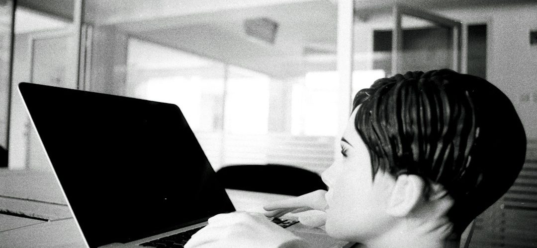 a young boy sitting in front of a laptop computer retro internet games bored student laptop browsing