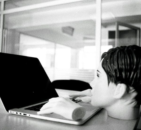 a young boy sitting in front of a laptop computer retro internet games bored student laptop browsing