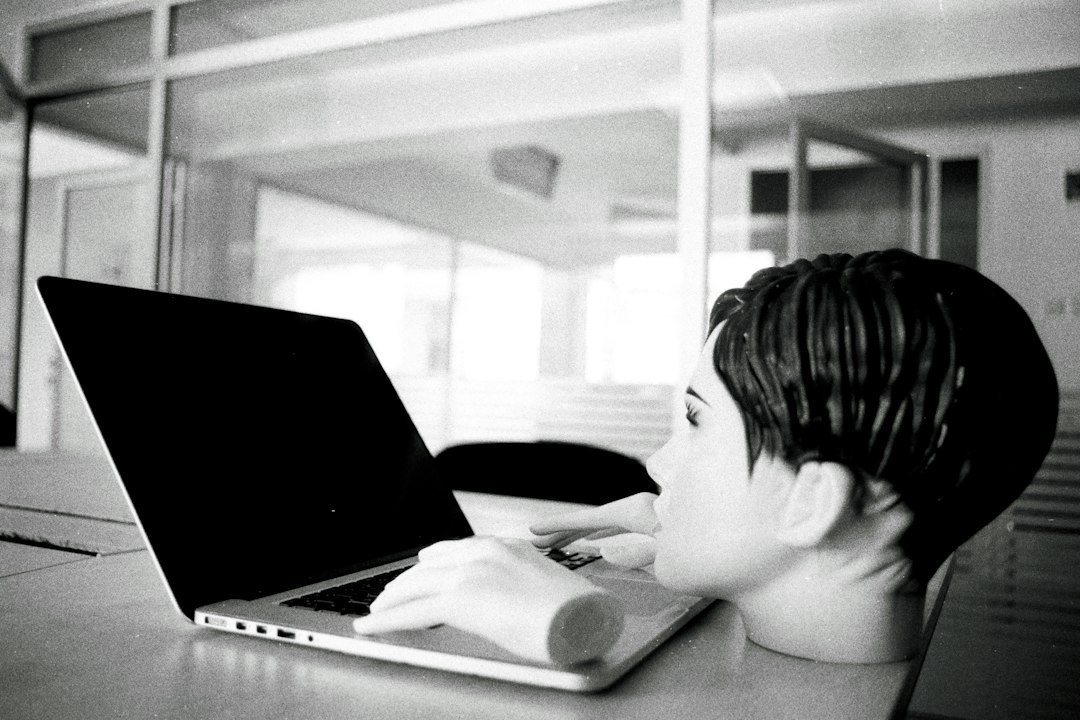 a young boy sitting in front of a laptop computer retro internet games bored student laptop browsing